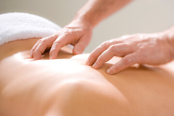 Naklejka premium A Massage Therapist Practitioner evaluates treatment for a patients back injury with therapeutic massage.