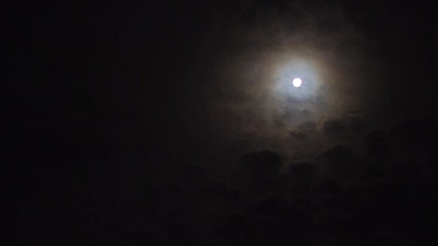 Real time video of beautiful night sky with full moon and clouds.