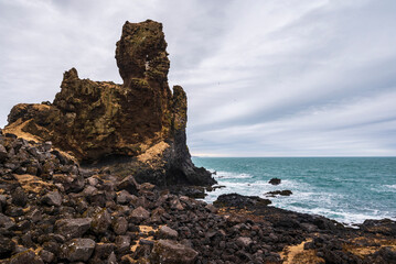 Coastal scenery at the impressive Lóndrangar basalt rock pinnacles on the coast near Malarrif,...