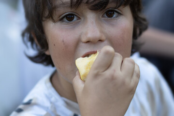 Brown-eyed cute boy eating an apple