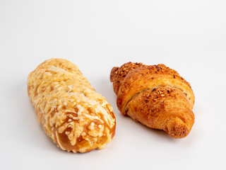 Baked goods croissant and cheese bun on white background.