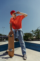 full length of man adjusting trendy sunglasses while standing with skate in park © LIGHTFIELD STUDIOS