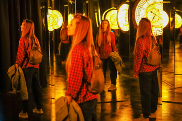 Woman in a mirror maze. Mirror labyrinth. Fairy tale museum with mirrors. Blurred image - 526155282