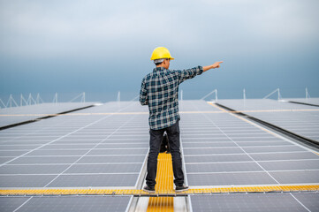 Asian Engineer use tablet working inspection installation solar cell on the roof. Technician maintenance solar cells on roof factory under morning sunlight. Technology solar energy renewable.