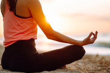 Fototapeta na wymiar Meditation. Young woman doing yoga near the ocean barefoot. Calmness and balance, a healthy lifestyle.