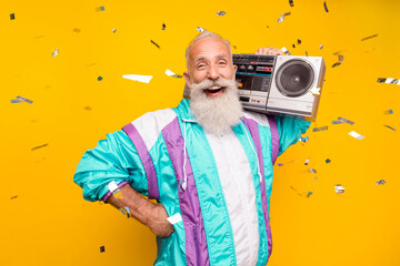 Portrait of funky positive granddad carry boom box have fun good mood isolated on yellow color...