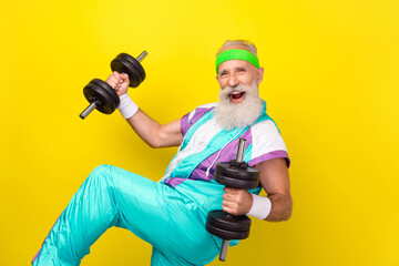 Profile portrait of crazy excited handsome man hands hold lift dumbbells isolated on yellow color background