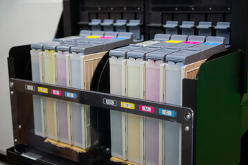 Row of inkjet printer CMYK cartridges - cyan, magenta, yellow, key or black colors - close up view.