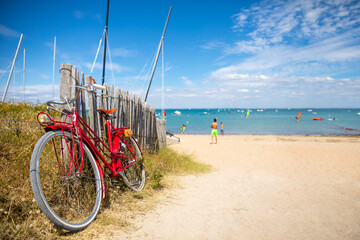 Fototapeta premium Vieux vélo rouge sur une plage bretonne en France.