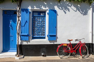 Vieux vélo rouge dans les rues d'un village de Vendée, Noirmoutier ou l'île de Ré en France.