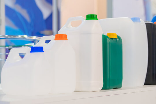 Row of empty plastic jerrycans at factory, exhibition - close up. Manufacturing, recycling, industry, technology equipment concept