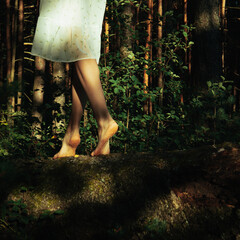 A girl walks on a fallen tree