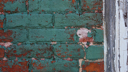 Old vintage red brick and peeled paint wall masonry exterior.