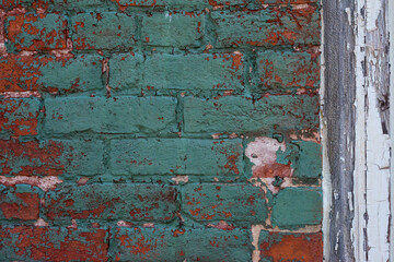Old vintage red brick and peeled paint wall masonry exterior.