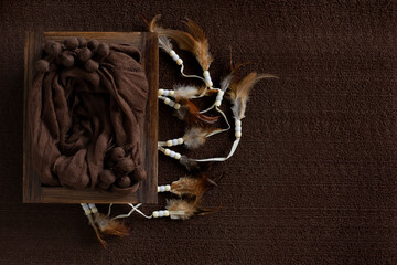 Newborn digital backdrop with baby space on a brown background, decoration with feather bird and wood box.