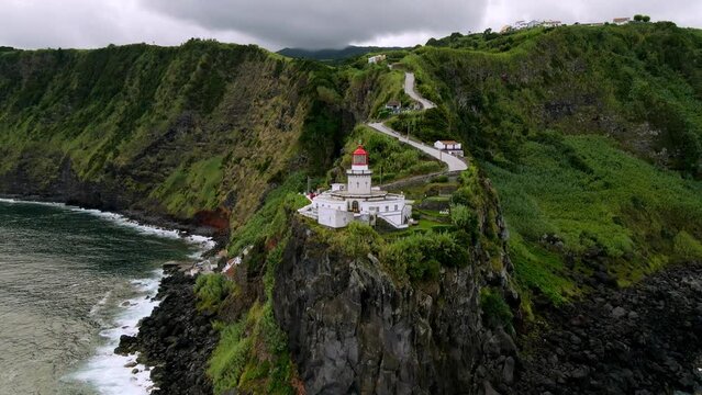 Drone flying around Lighthouse Farol Ponta do Arnel. Aerial view of amazing landscape of green island in atlantic ocean, 4k footage. Sao Miguel, Azores, Atlantic Coastline