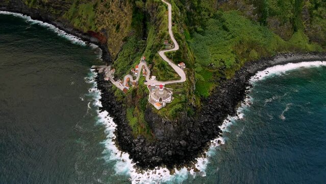 Reveal ascending drone shot of Lighthouse Farol Ponta do Arnel on San Miguel Island. Aerial view of amazing landscape of green island in atlantic ocean, 4k footage. Azores, Atlantic Coastline