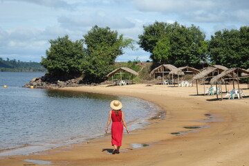 Mulher andando de costas na praia do massanori, em Altamira, Pará, margens do rio Xingu