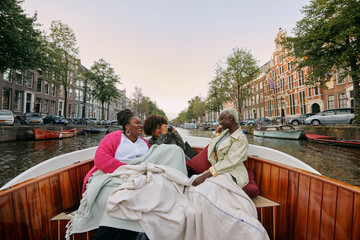 Female friends clicking photos while enjoying in boat © Faces of Travel