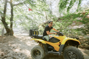 Blurred motion of man riding ATV bike on dirt road © Faces of Travel