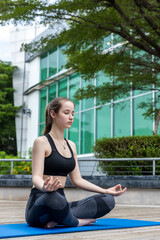 Fototapeta premium Woman doing yoga at outdoors garden. Woman is stretching in yoga at Garden. work out time 