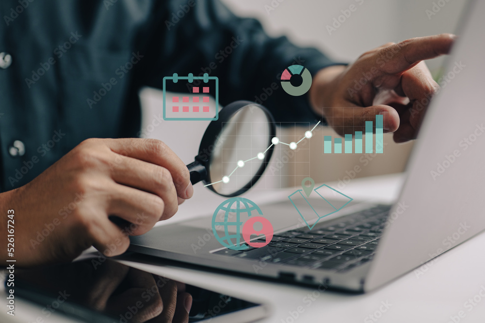 Poster Magnifying glass in hand, a smart business analyst examines graphs and charts while calculating or researching market expansion, financial reports, investment data, or sales information concepts.