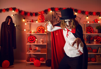 It's spooky season. Adult man dressed in Halloween costume of crazy evil vampire doing claw hand...