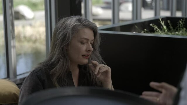 Medium shot mature woman placing order in restaurant