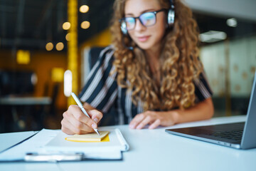 Education and working online. Young woman with glasses working on laptop. Technology, Freelance, online course, remote work and lifestyle concept.