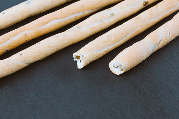 Fresh Italian Grissini Breadsticks served on black background. Dry