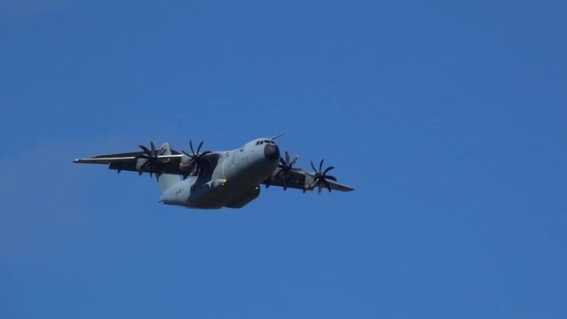 Royal Air Force Airbus A400M Atlas military plane (RAF ZM414) flying low level dropping 3 PARA parachute regiment soldiers on an airborne assault military exercise, summer bright cloud sky