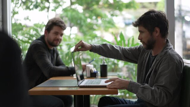 Young man opening latop computer at coffee shop using modern technology remotely at cafe restaurant