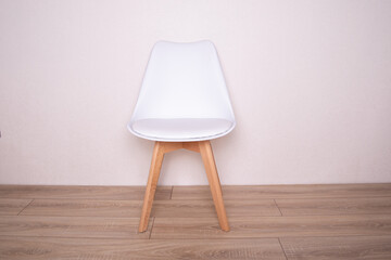 
Modern white leather chair on wooden background