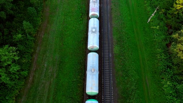 Freight train with petroleum tank cars. Rail cars carry oil, crude and gas, ethanol. Tank car LNG by rail, natural gas. LPG transport propane. Fuel train, rolling stock with petrochemical tank cars. 