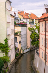 Fototapeta na wymiar Scenic view of a canal that runs between old houses in the old center of Prague, Czechia