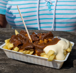 Lunch with traditional street food in Belgium, French fried potatoes with beef stew and mayonnaise