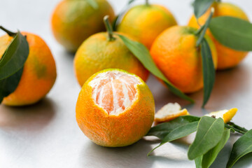Clementine with leaves, one peeled