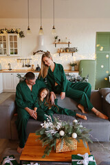 New Year, family mom, dad and little beautiful daughter in the kitchen in bright colors, decorated...