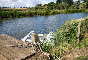 Small rubber dinghy moored against the wooden quay heading