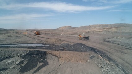 Hard coal spills out of a crowded mining truck on a sharp curve