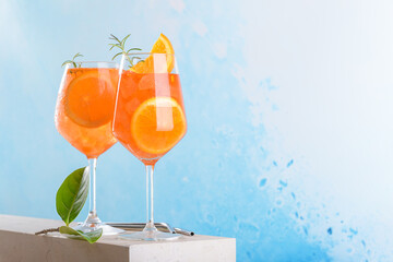 Classic italian aperitif aperol spritz cocktail in two wineglasses with ice cubes and slice of...