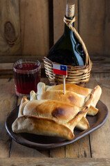 Chilean independence day concept. fiestas patrias. Tipical baked empanadas de pino, wine or chicha,...