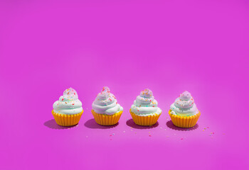 Colorful cupcakes on vibrant violet background. Creative minimal summer concept.