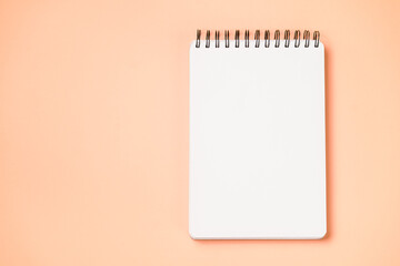 School notebook on a paper yellow background, spiral notepad and craft cardboard pen