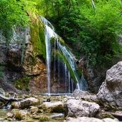 Fototapeta na wymiar Beautiful waterfall in the summer forest