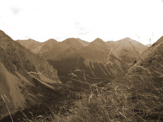 Vintage misty landscape with hills and rocks in sepia tones.