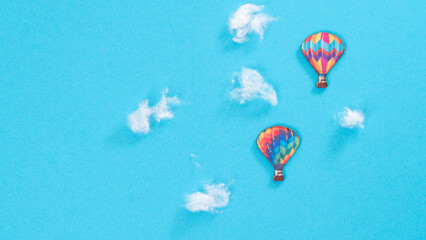 Flight of balloons in the clouds, blue background with space for text
