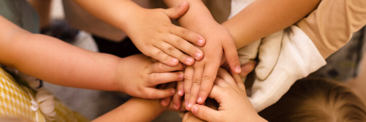 Children's hands piled on top of each other. Children's team and team building among the little child. Web banner