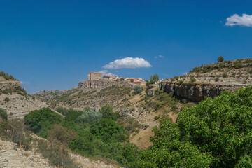 Vista panor&aacute;mica de Moscard&oacute;n al borde de un barranco en Teruel con su Iglesia de San Pedro  Ap&oacute;stol  sobresaliendo sobre la poblaci&oacute;n