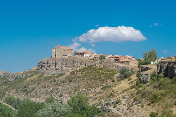Fototapeta na wymiar Vista panorámica de Moscardón al borde de un barranco en Teruel con su Iglesia de San Pedro Apóstol sobresaliendo sobre la población
